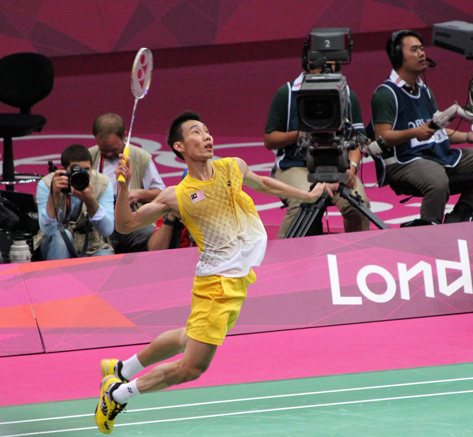 Badminton player leaping for a jump smash during a match
