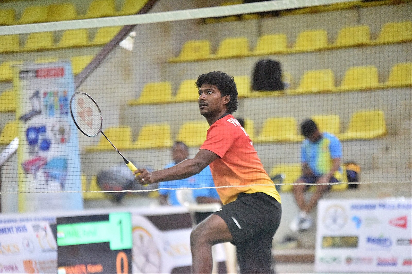 Badminton player ready on court with racket in hand during a match