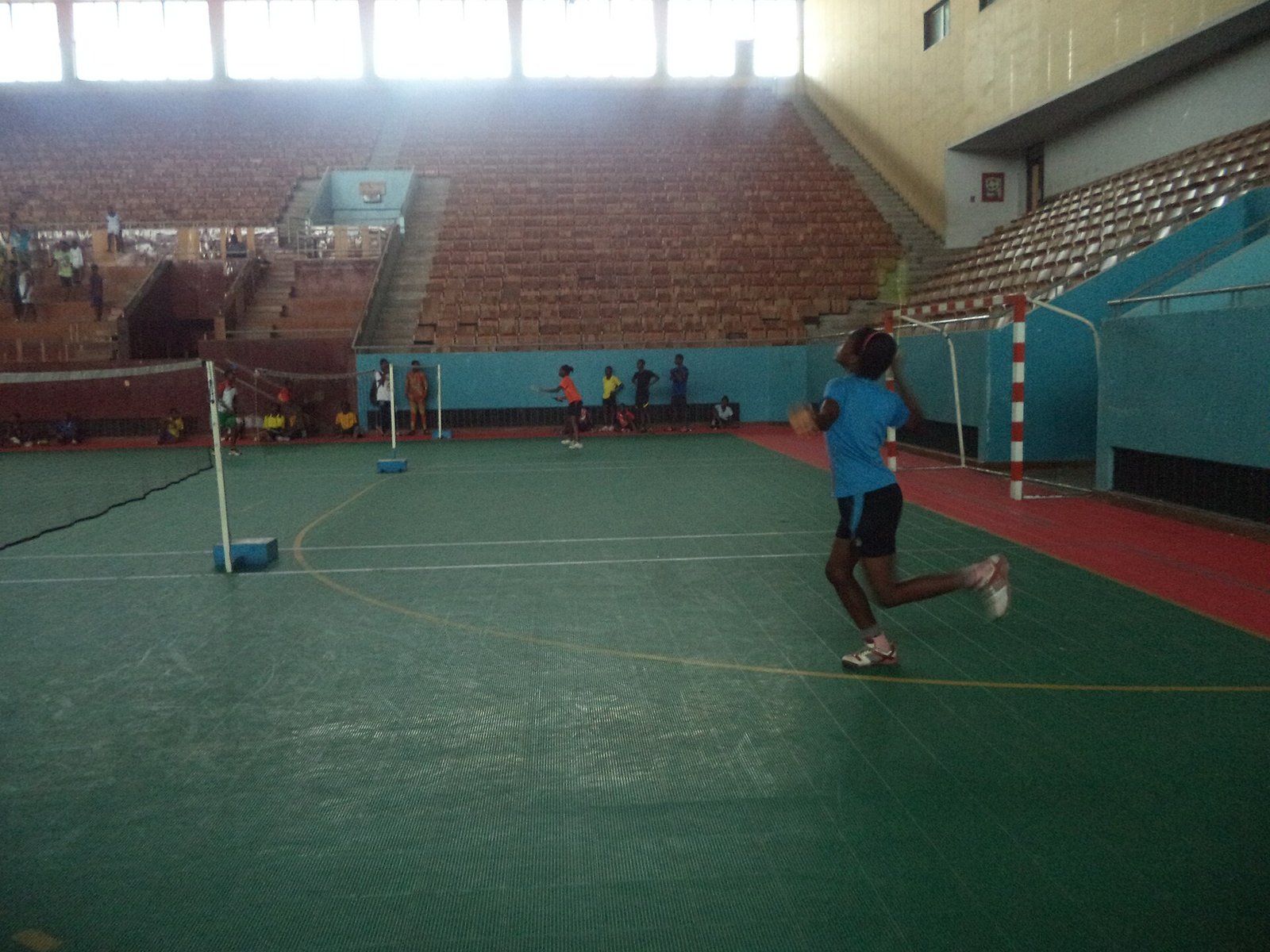 Women players competing in an indoor badminton match
