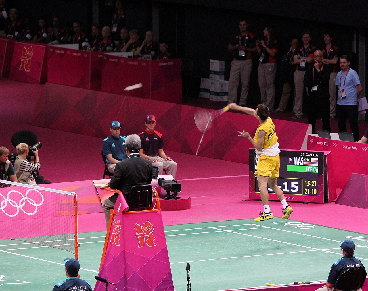 A badminton player stretched into a deep lunge returning a smash
