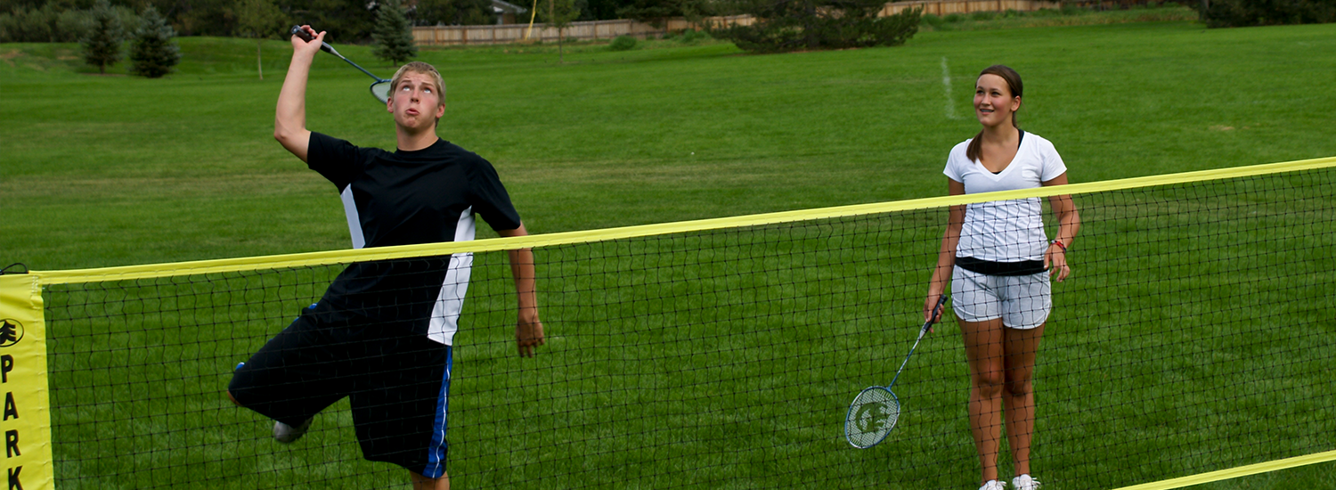 Family badminton set with net set up in a green park for a garden game