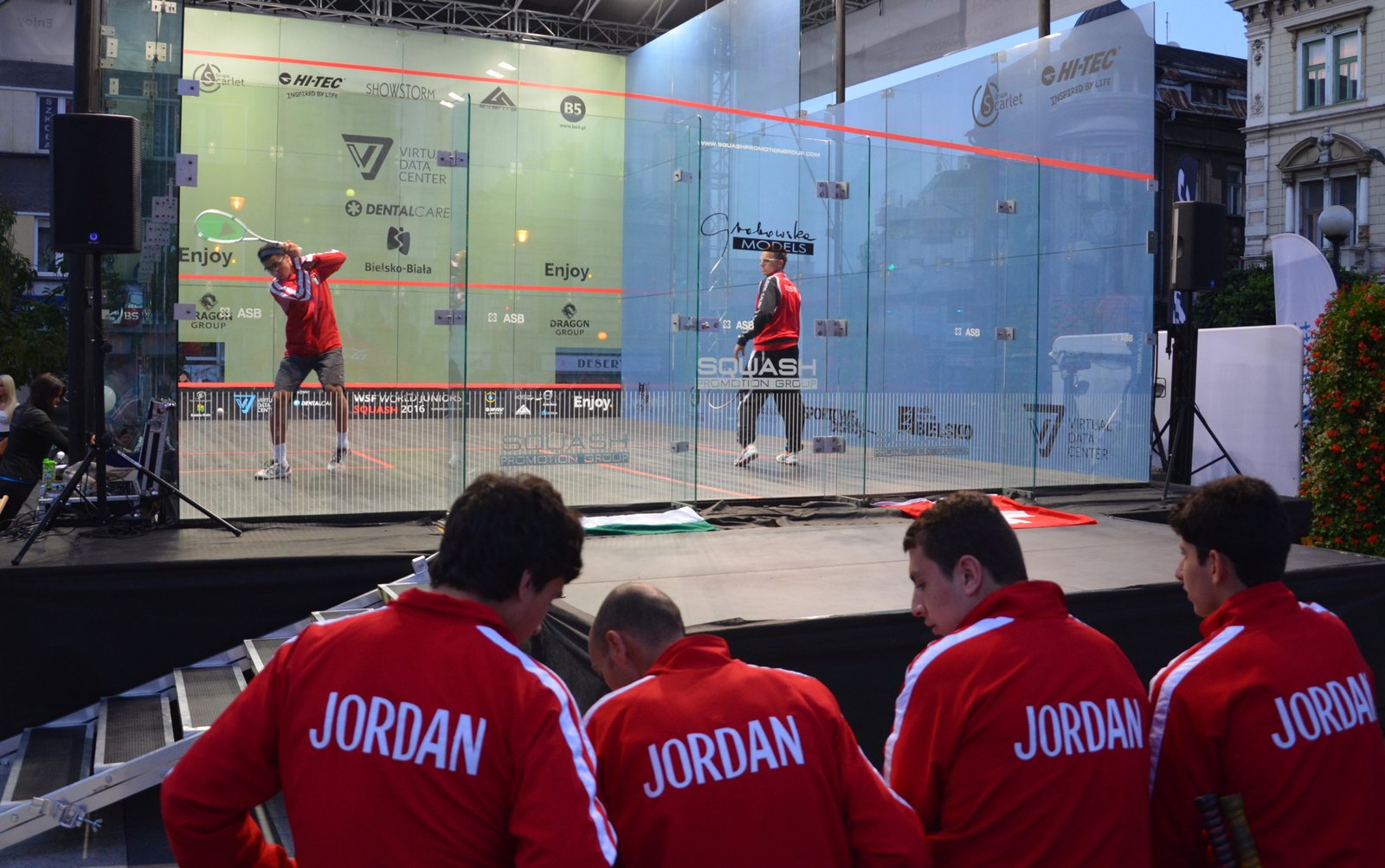 Junior players competing on a glass-backed court at the World Junior Squash Championships
