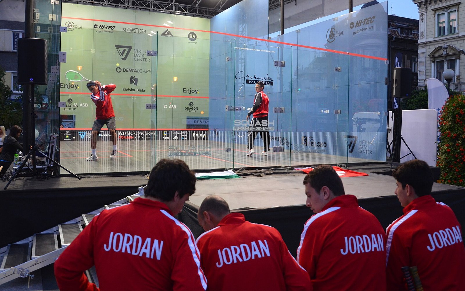 Junior players competing on a glass-backed court at the World Junior Squash Championships