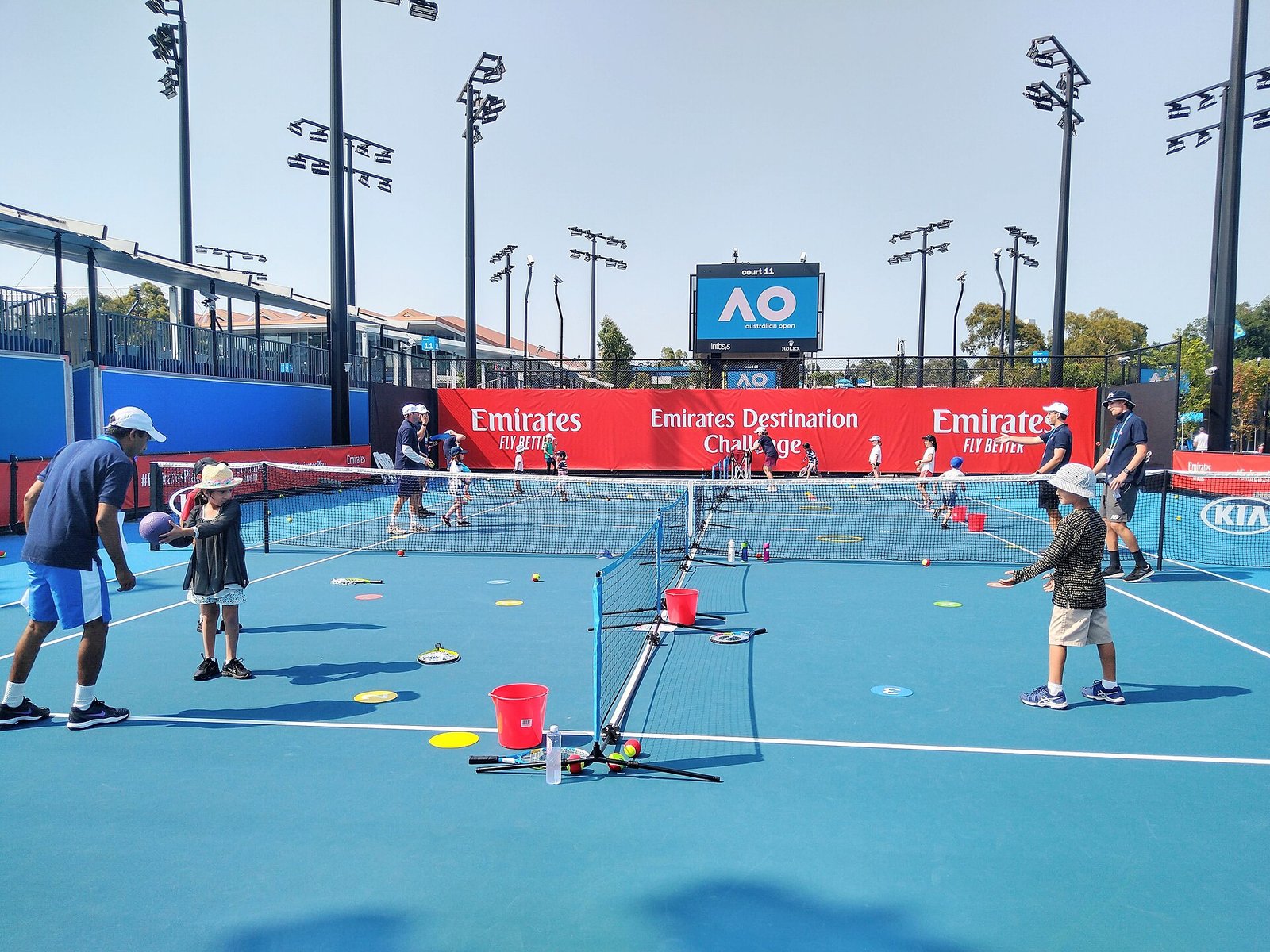Children playing tennis with junior rackets at a kids tennis day event