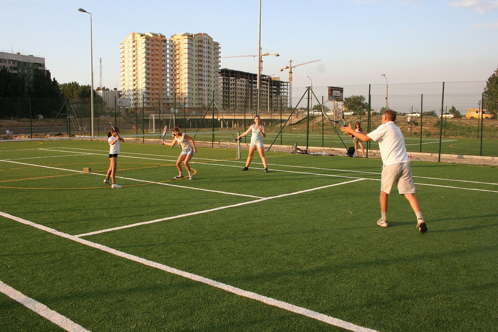 Young players training on court with junior tennis rackets