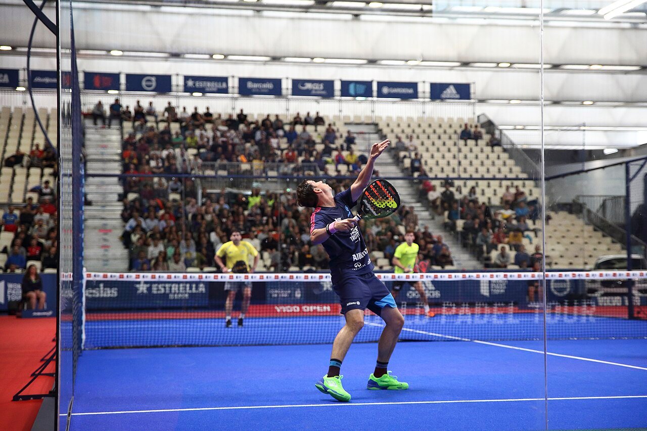 Professional player attacking the ball at the net during a World Padel Tour match