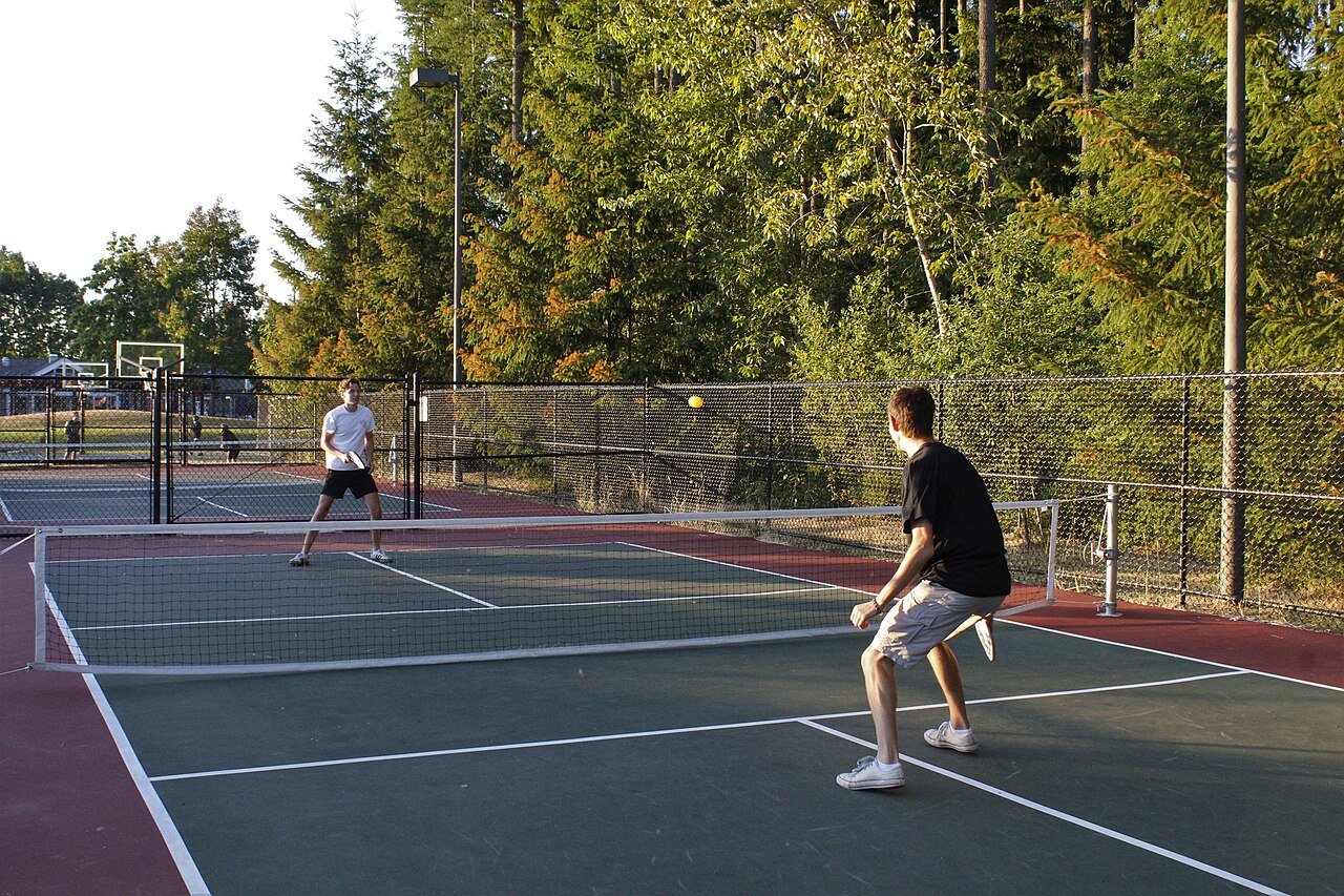 Advanced pickleball players in a fast doubles rally at the net