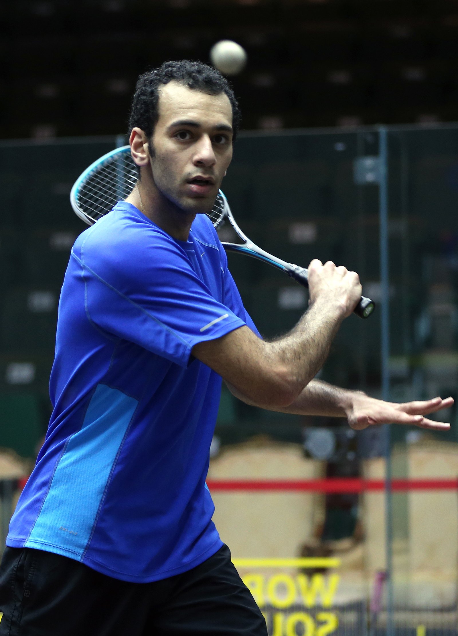 Squash player striking the ball during a competitive match rally