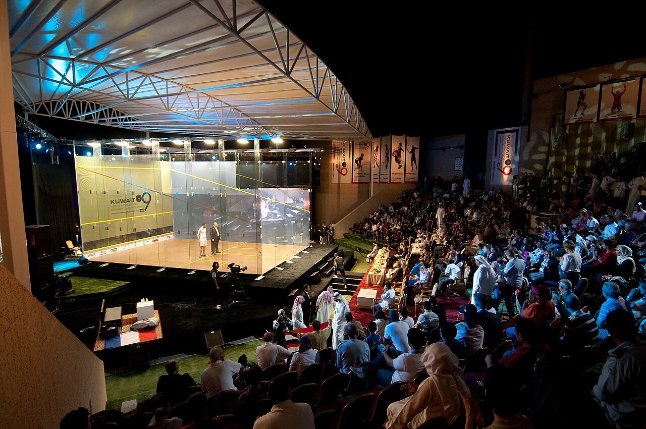 Professional squash players contesting a rally on a glass-backed show court at the PSA Kuwait Cup