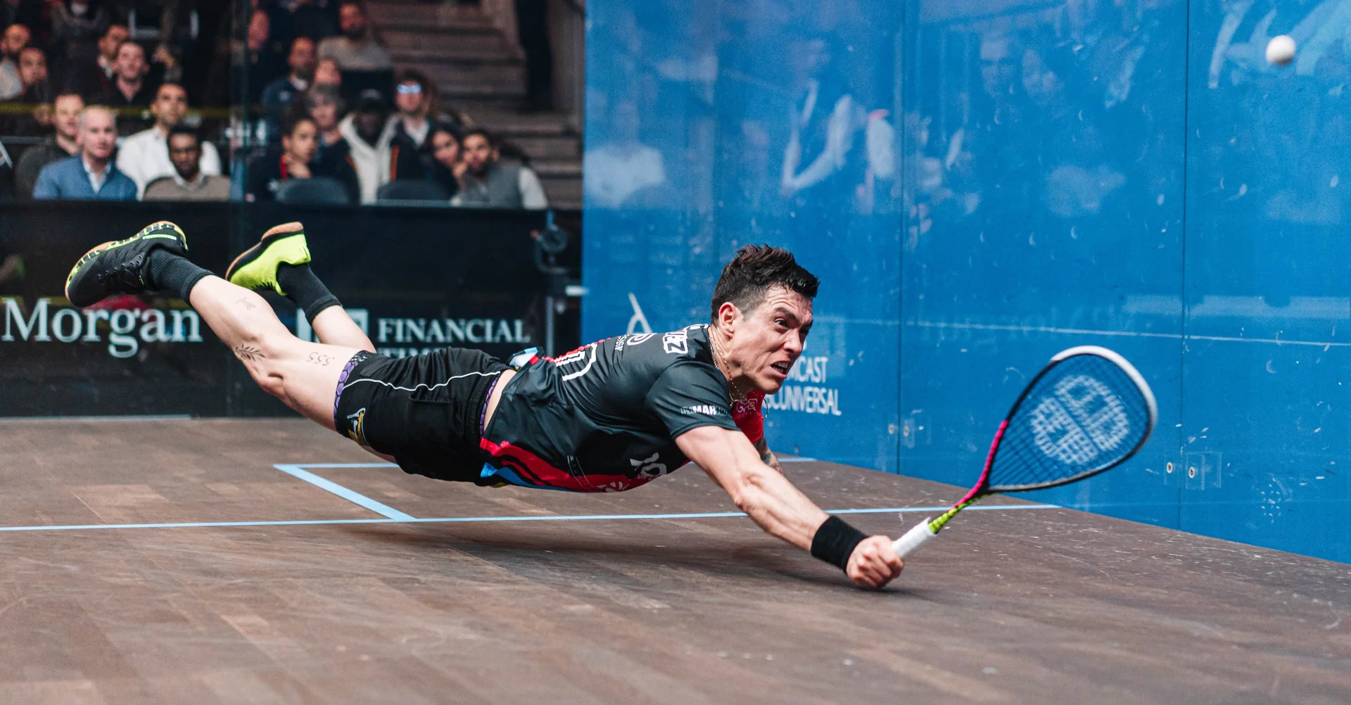 Professional squash player stretching into a deep front-court lunge during a tournament rally