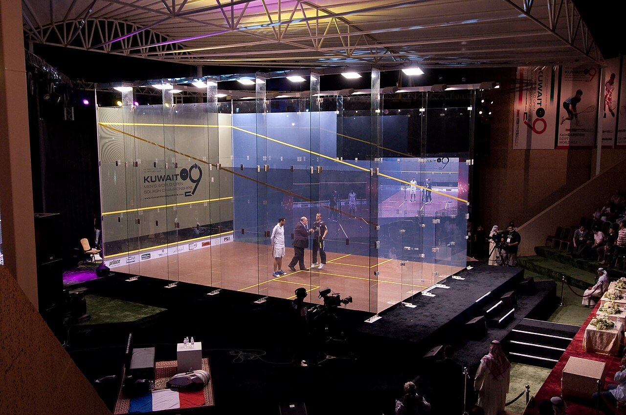 Professional squash players contesting a rally on a glass-backed show court
