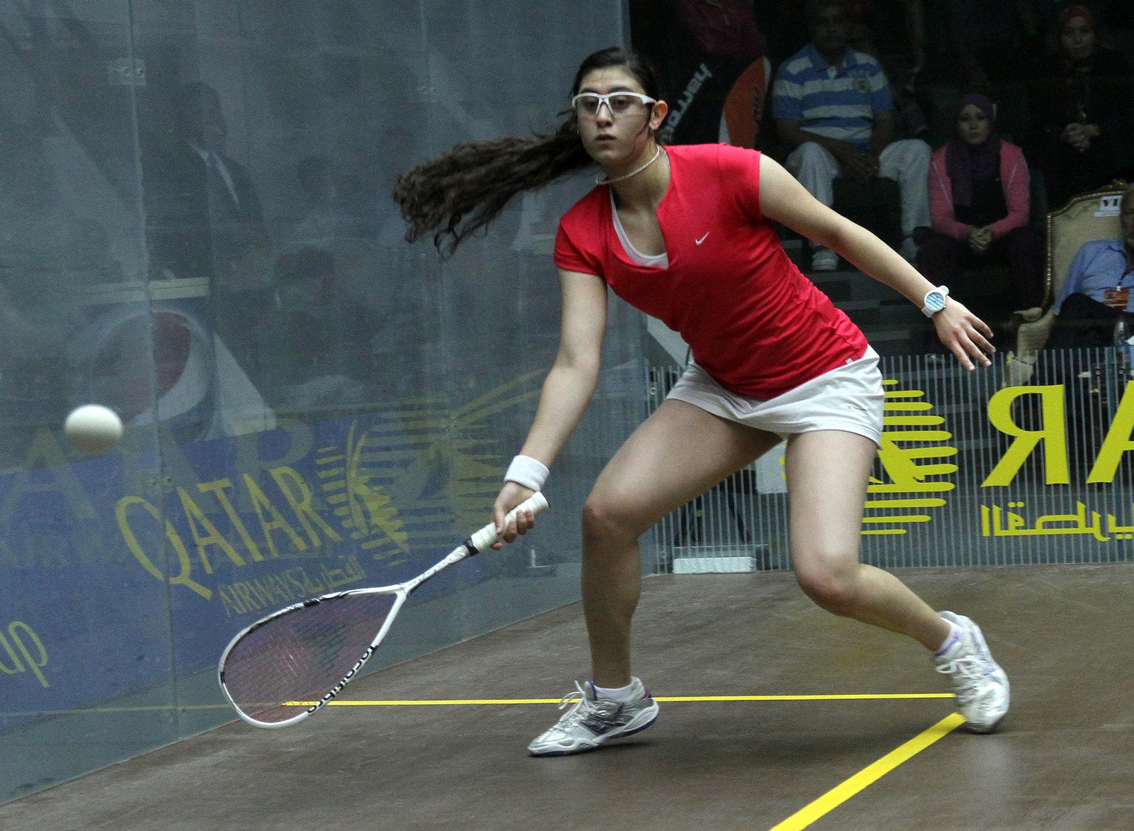 Squash player playing a shot at the front of the court during a match