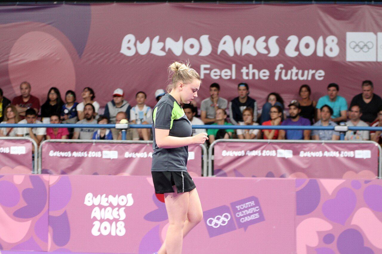 Doubles partners moving side by side around the table during a table tennis match