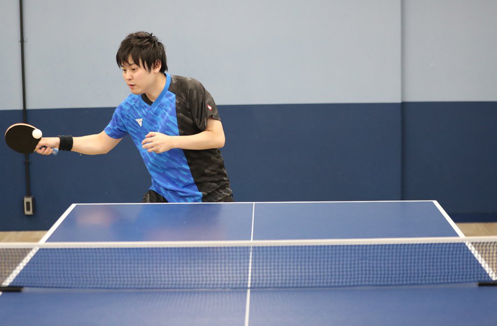 Table tennis player moving through a two-point footwork drill during a training session