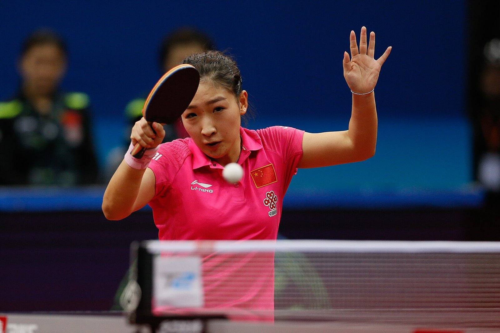 Professional table tennis player in a low ready stance tracking the ball during an Asian Championships rally