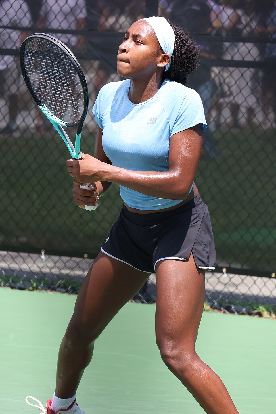 Tennis player striking a forehand on an outdoor hard court