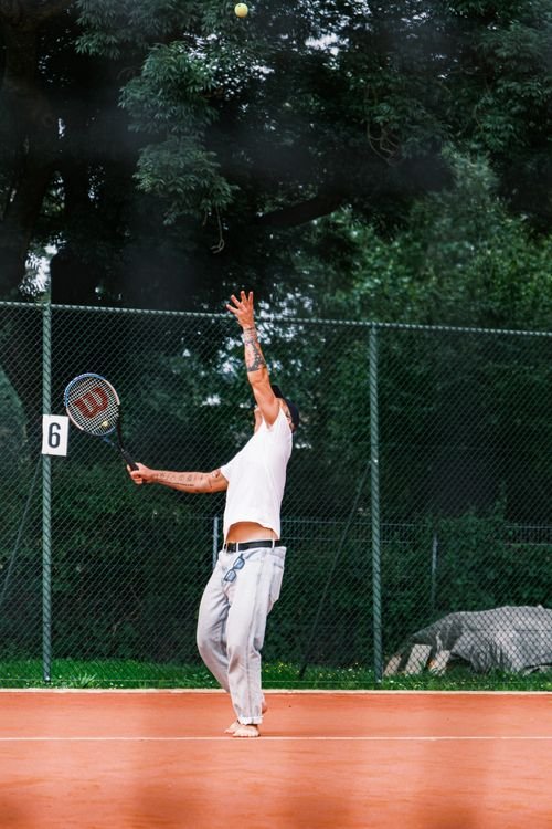 Tennis player serving on an outdoor clay court