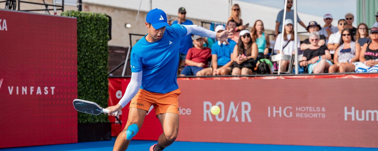 Advanced pickleball player driving the ball from the transition zone during a competitive match