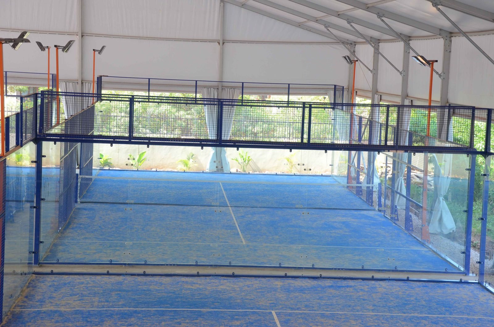 Outdoor padel court in bright daytime sunshine with nobody playing on it